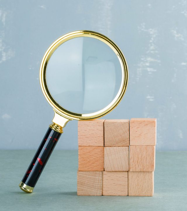 conceptual-search-with-wooden-blocks-magnifying-glass-side-view-min
